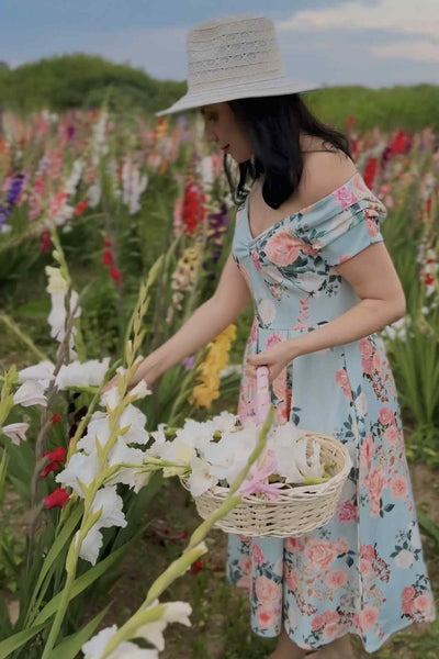 A model wearing a 50's Style Floral Off Shoulder Dress In Mint