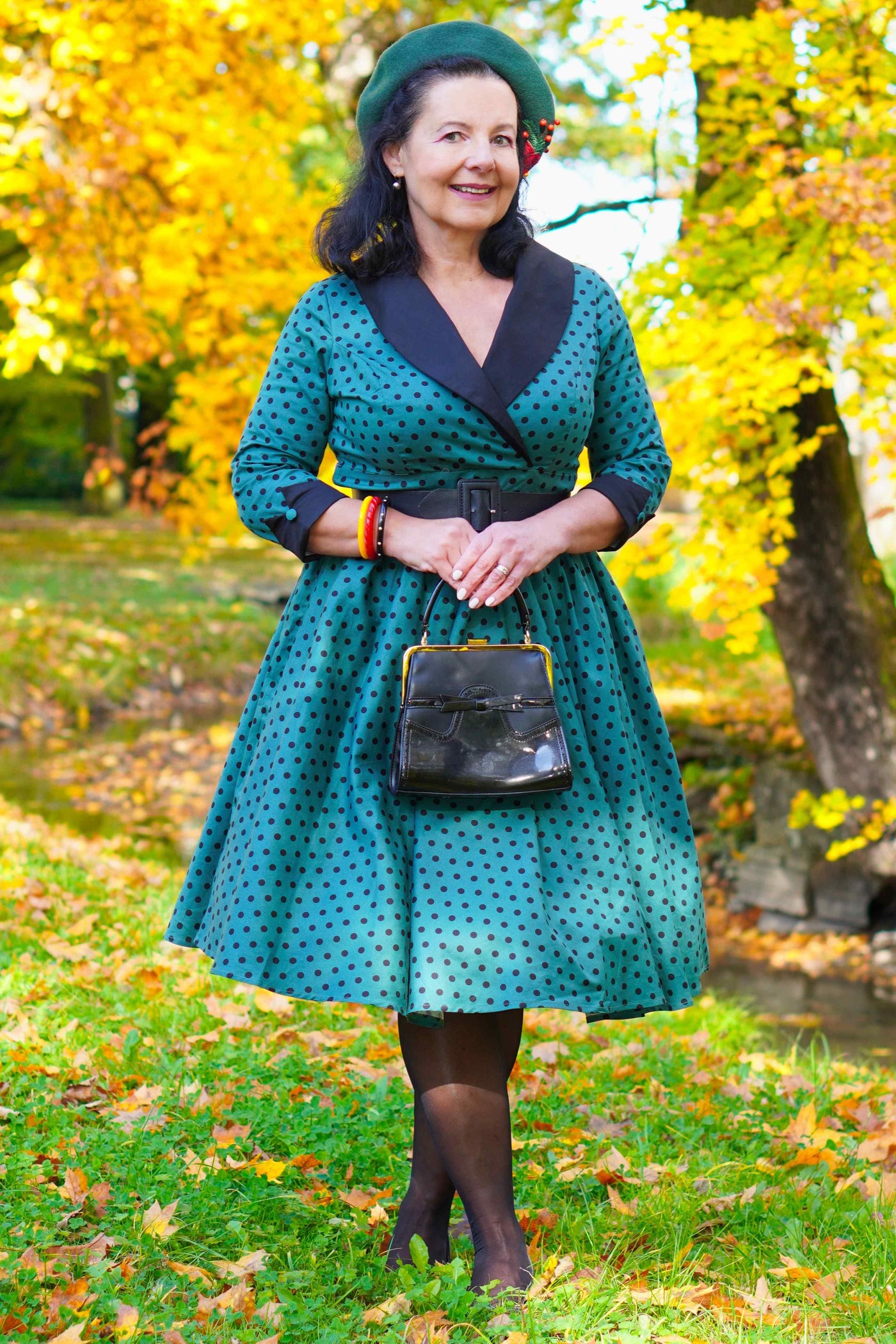 A lady wearing a Coat Dress in Green & Black Polka Dots