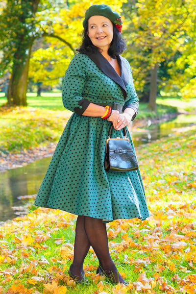 A lady wearing a Coat Dress in Green & Black Polka Dots