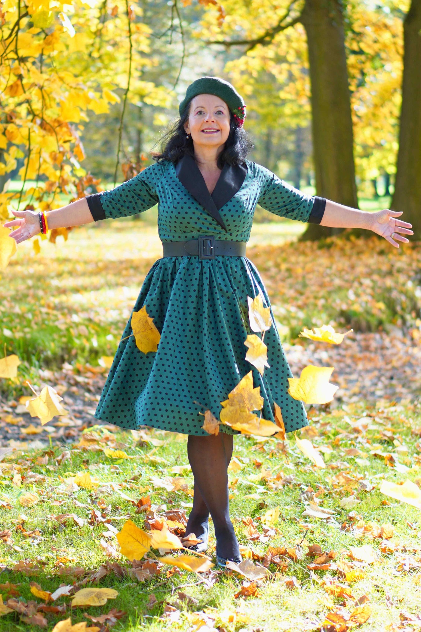 A lady wearing a Coat Dress in Green & Black Polka Dots