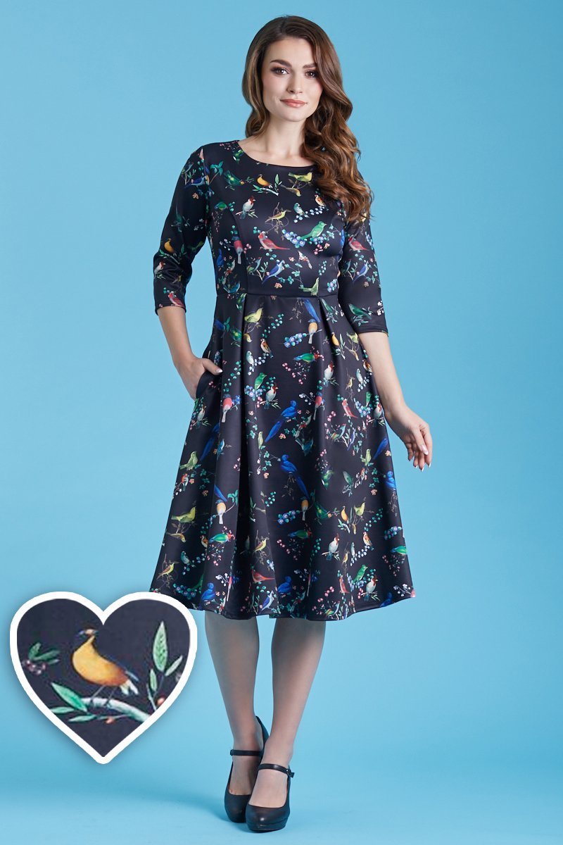 A model wearing Long Sleeved Midi Dress in Black Bird Print