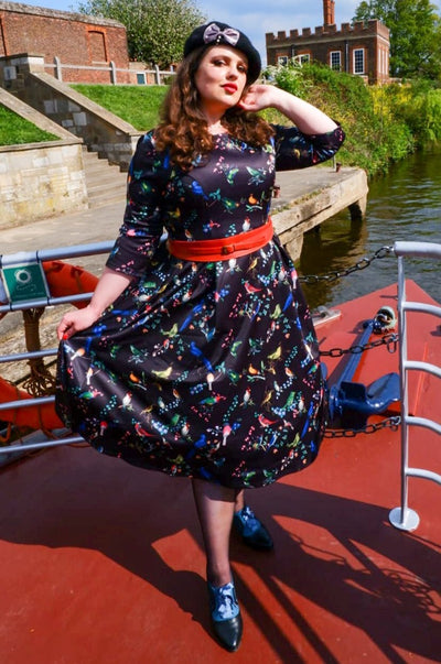 A model wearing Long Sleeved Midi Dress in Black Bird Print