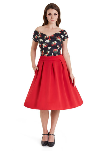 Model wears our V neck, off shoulder, short sleeve top, in black, with red strawberry print, with red skirt, top view