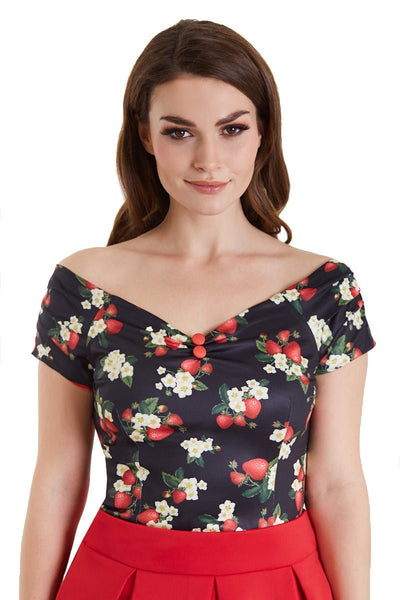 Model wears our V neck, off shoulder, short sleeve top, in black, with red strawberry print, top view