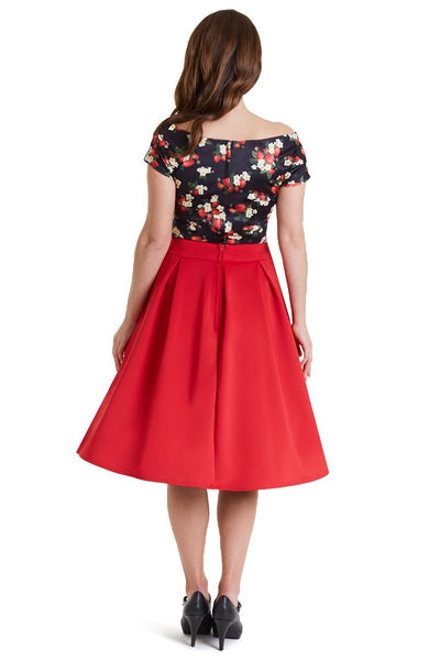 Model wears our V neck, off shoulder, short sleeve top, in black, with red strawberry print, with red skirt, back view