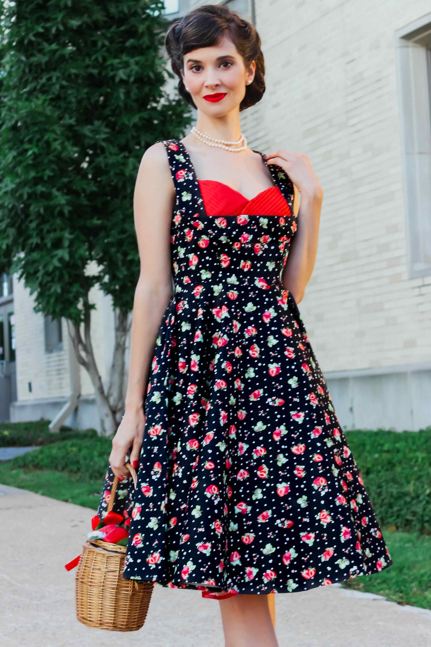 A model wearing a Black Strawberry Pleated Bust Dress