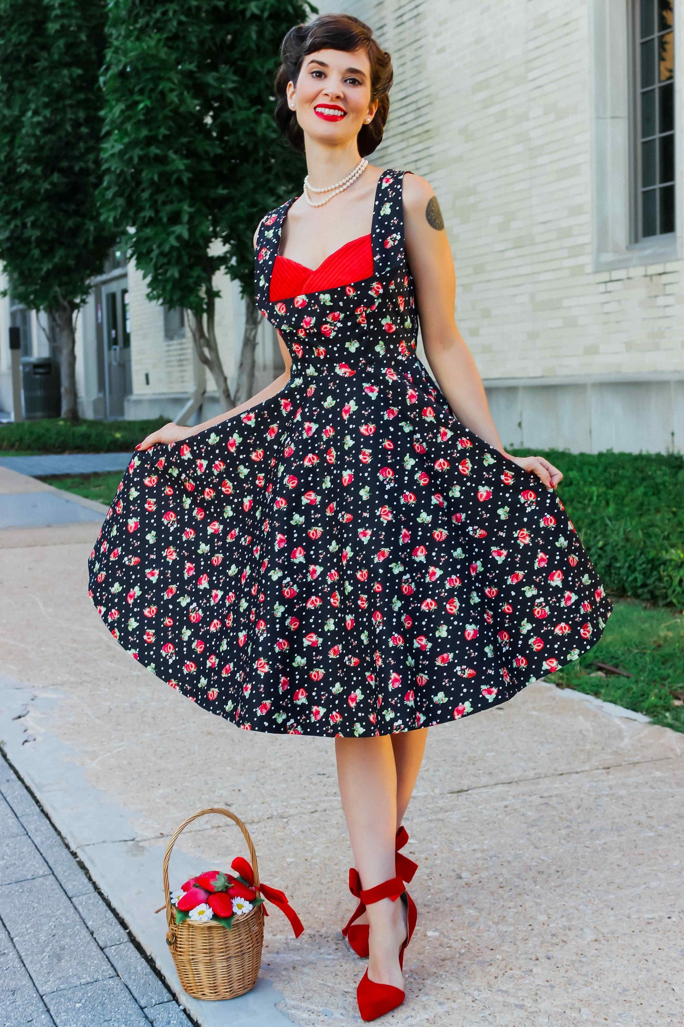 A model wearing a Black Strawberry Pleated Bust Dress