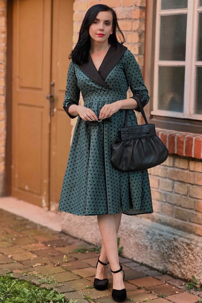 A lady wearing a Coat Dress in Green & Black Polka Dots