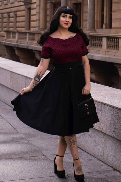 A lady wearing a Full Circle Swing Dress in Burgundy Polka-Black