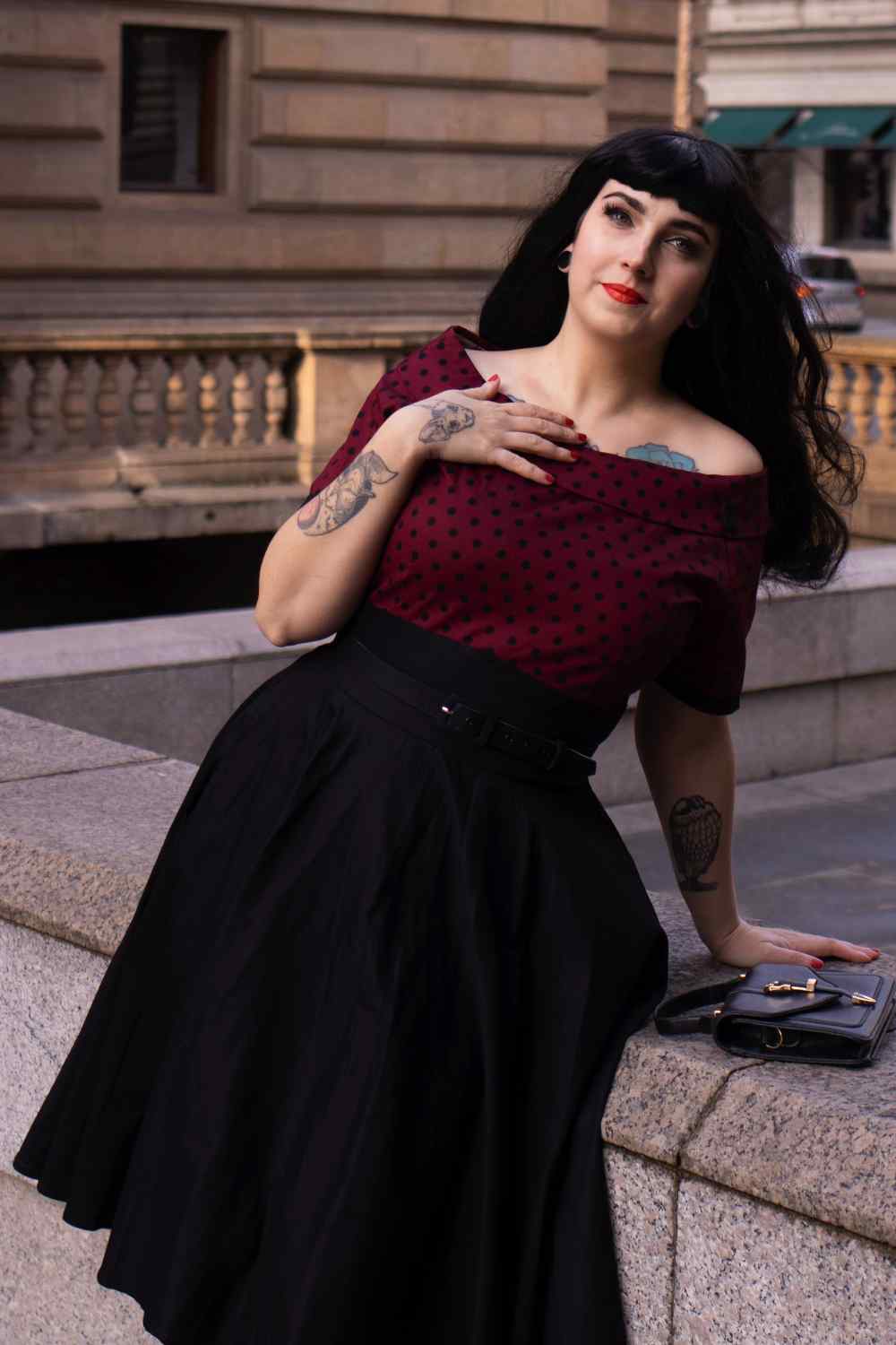 A lady wearing a Full Circle Swing Dress in Burgundy Polka-Black