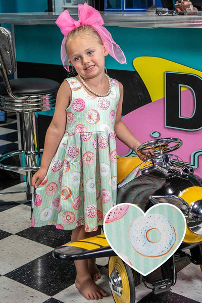 A cute child wearing a Kids Donut Green Swing Dress