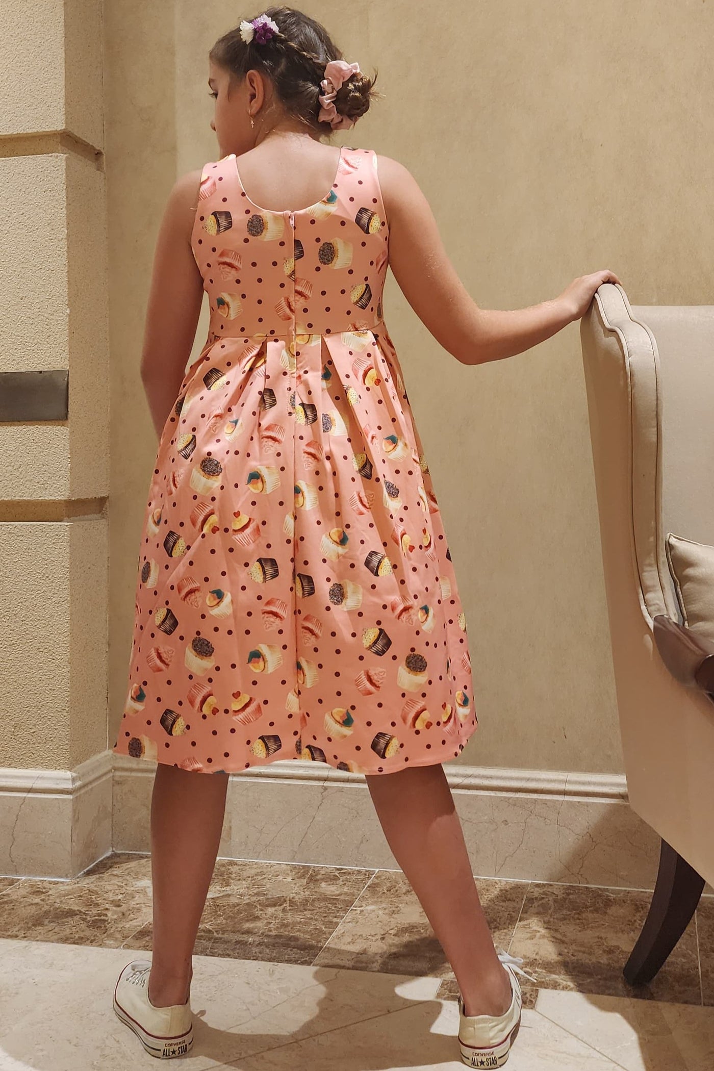 A pretty girl wearing a Kids Pink Cupcake Swing Dress