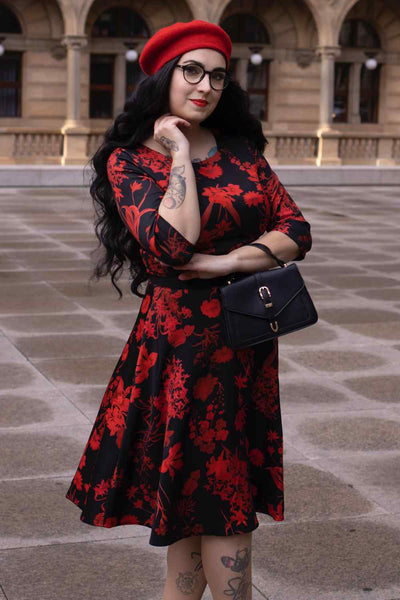 A lady wearing a Long Sleeved Midi Dress in Black/Red Floral