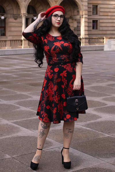 A lady wearing a Long Sleeved Midi Dress in Black/Red Floral