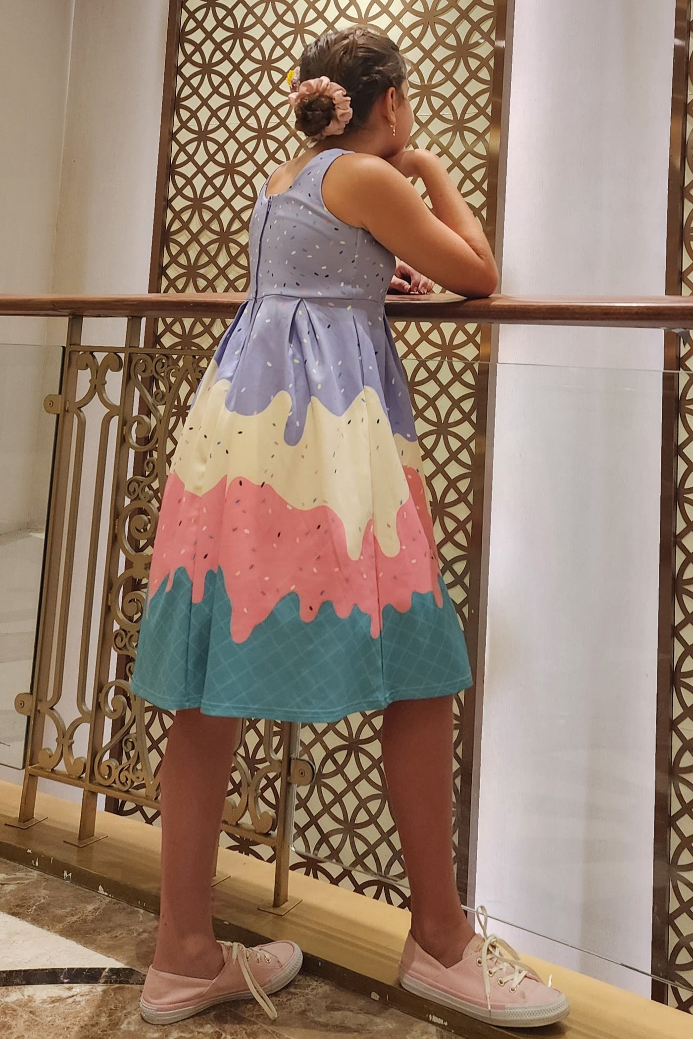 A pretty girl wearing a Kids Melted Ice Cream Swing Dress