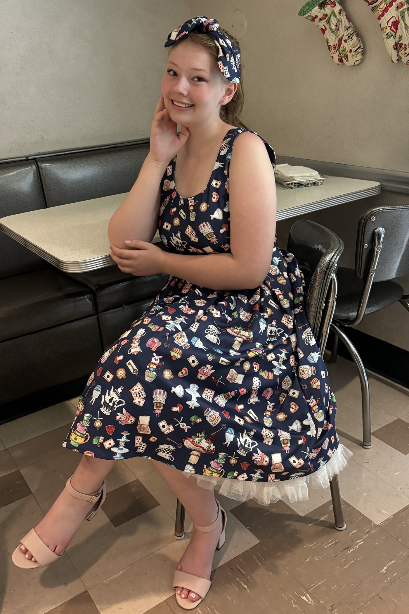 A model wearing Navy Blue Wonderland Swing Dress and headband