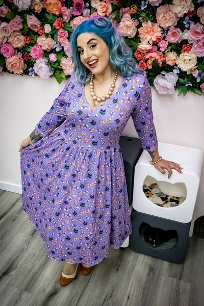 Customer wears our long sleeved midi dress, in purple cats-with-glasses print