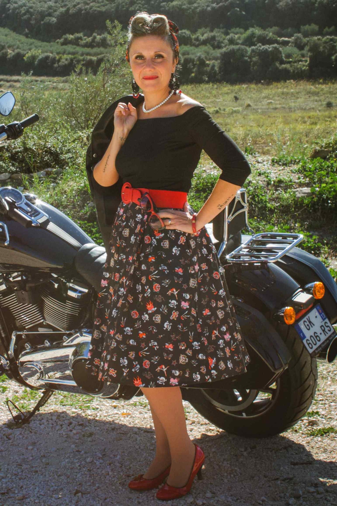 A lady wearing a Rockabilly Off Shoulder Black Top and Rockabilly Old School Tattoo Flared Skirt