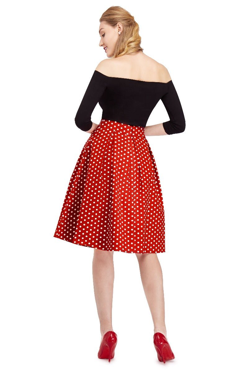 Model wears our black top and high waisted, flared skirt, in red polka dot print, back view