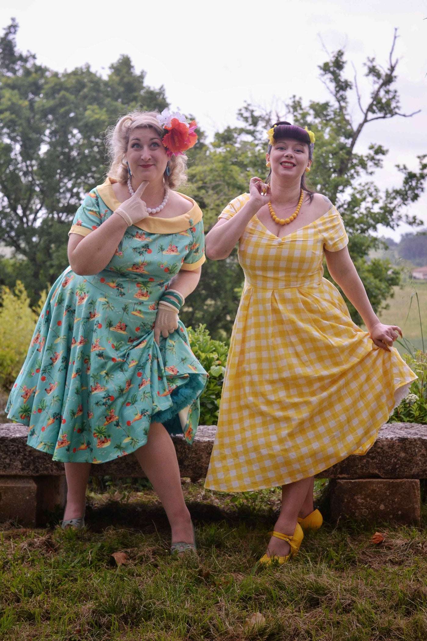 Models wearing Turquoise Pinup Swing Dress in Tropical Island Print and Off Shoulder Yellow Gingham Dress